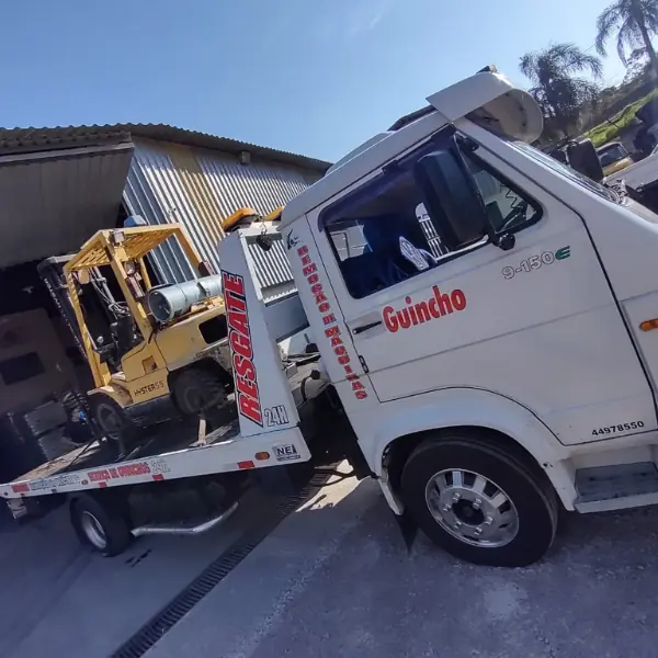 Caminhão VW 9-150 com plataforma transportando uma empilhadeira