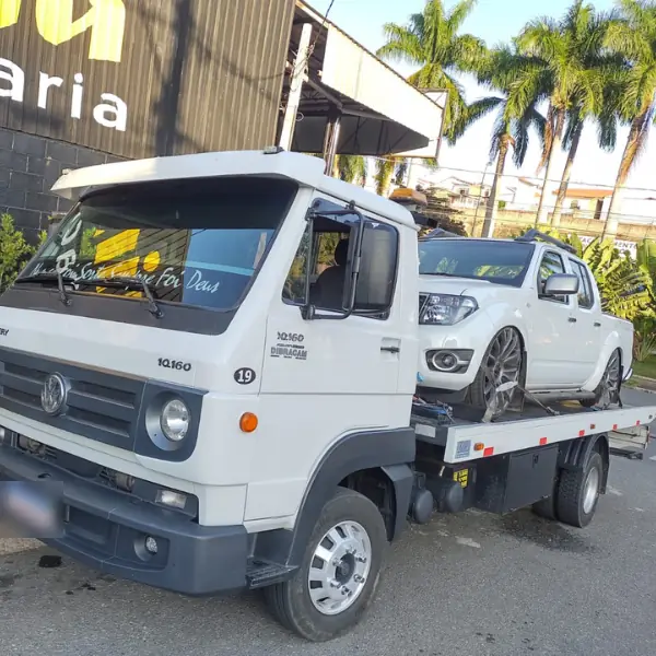 Caminhão VW Delivery 10.160 com plataforma transportando uma picape