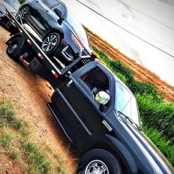 Guincho F-250 transportando um SUV preto na plataforma